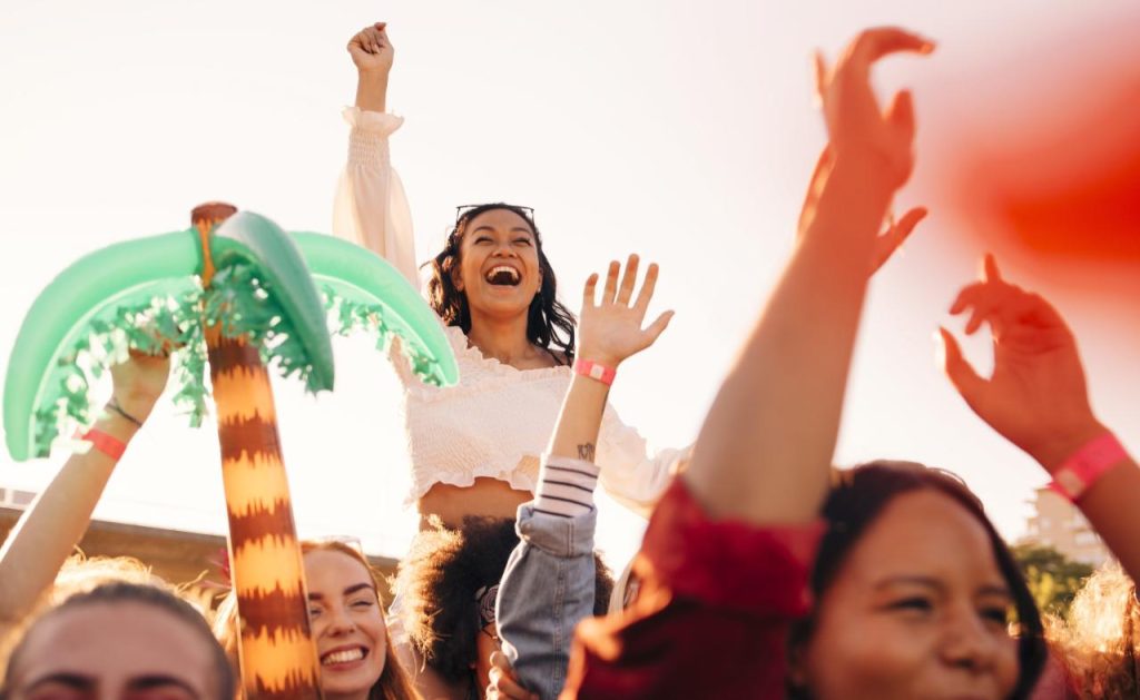 Happy young enthusiastic fans enjoying in music festival
